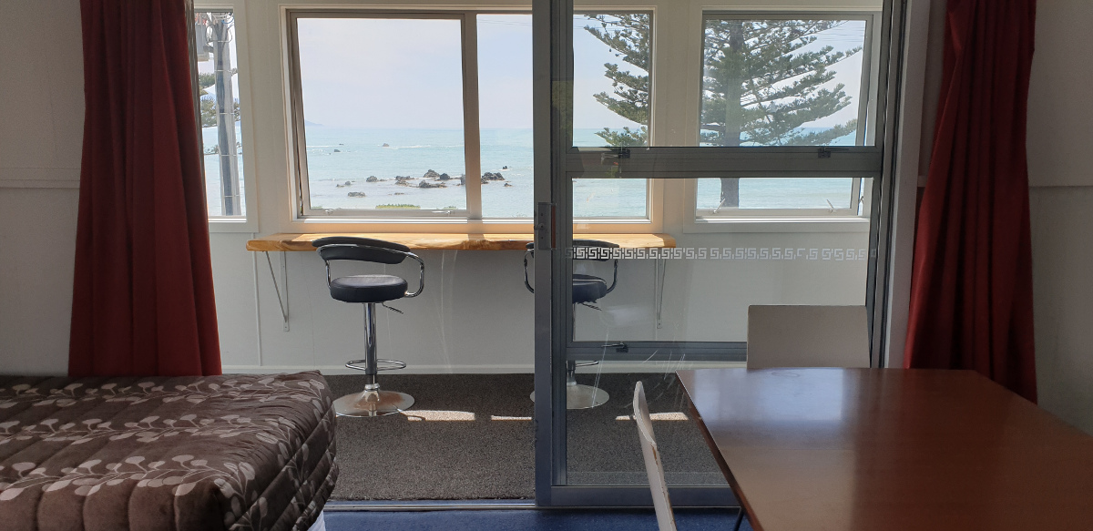 This is an upstairs unit that with not only looks directly out over the ocean but also magnificent views of the Kaikoura ranges. Bedding in this unit is a queen bed and 2 single beds all in the same studio space as the living and cooking areas.
